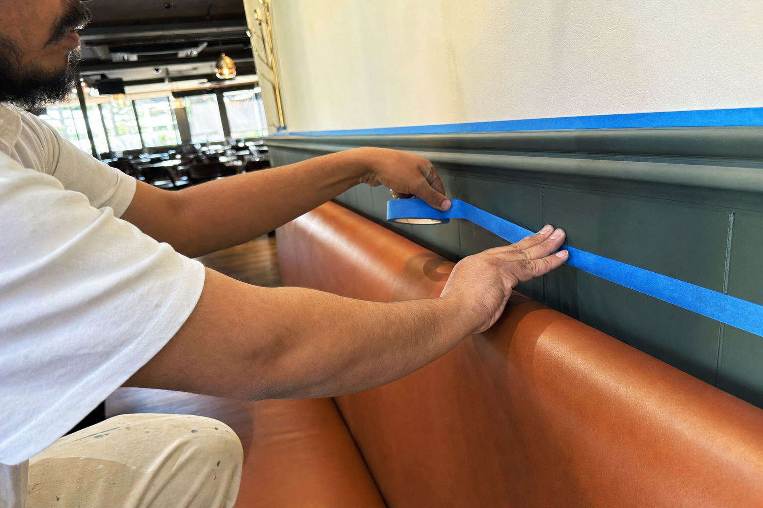 Masking off booths and trim before a restaurant repaint